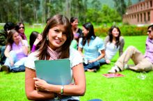 Beautiful female student outdoors with a group behind
