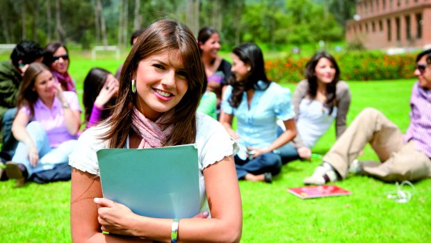 Beautiful female student outdoors with a group behind